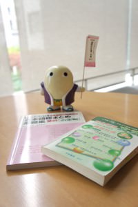 Mayumaro, one of Kyoto Prefecture's cute mascots (he's a silkworm cocoon!) stands guard over some of Rae's study materials.